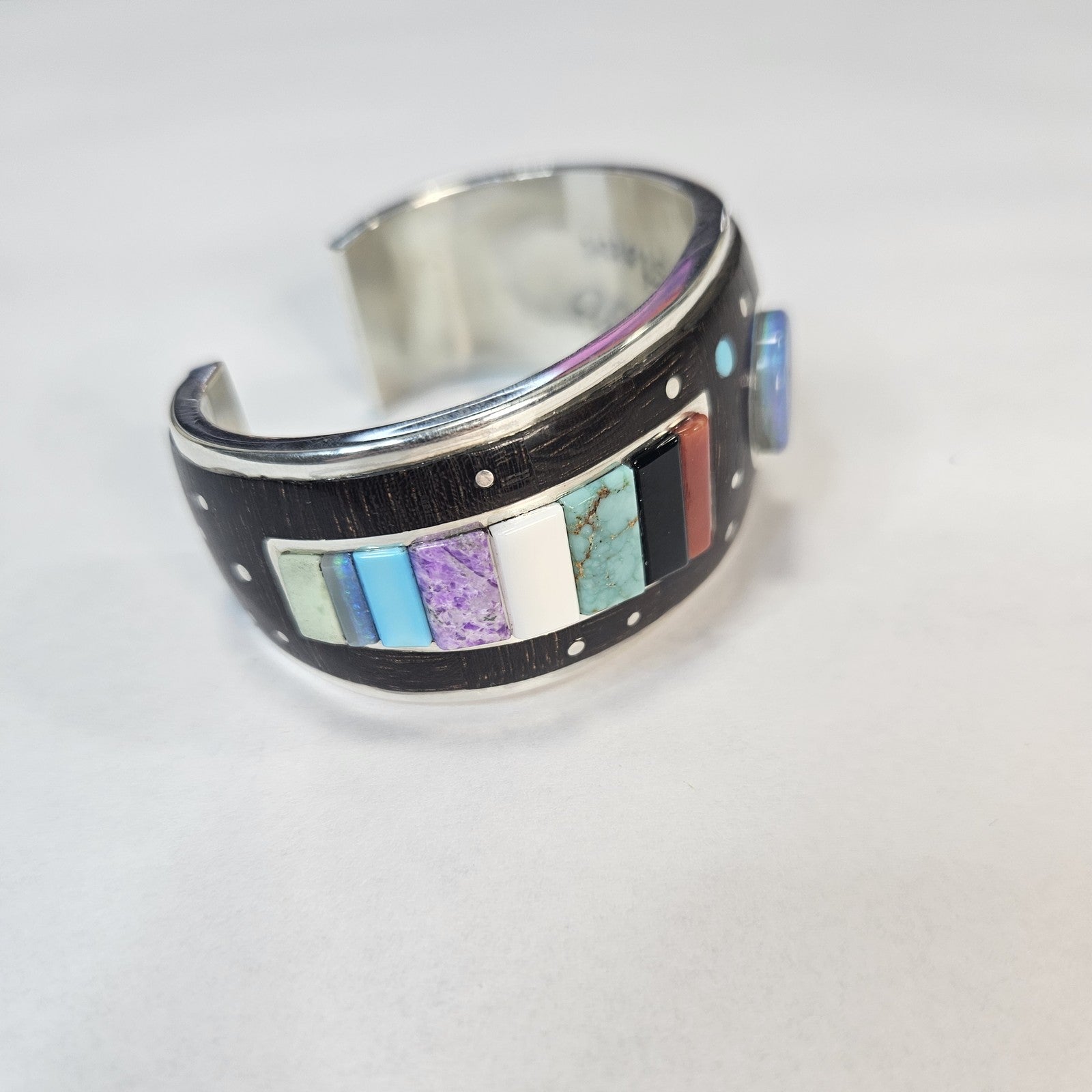 Multistone inlay cuff with central lapis cabochon and turquoise, coral, mother of pearl, and silver-dot constellation detail — Navajo handcrafted by Teddy