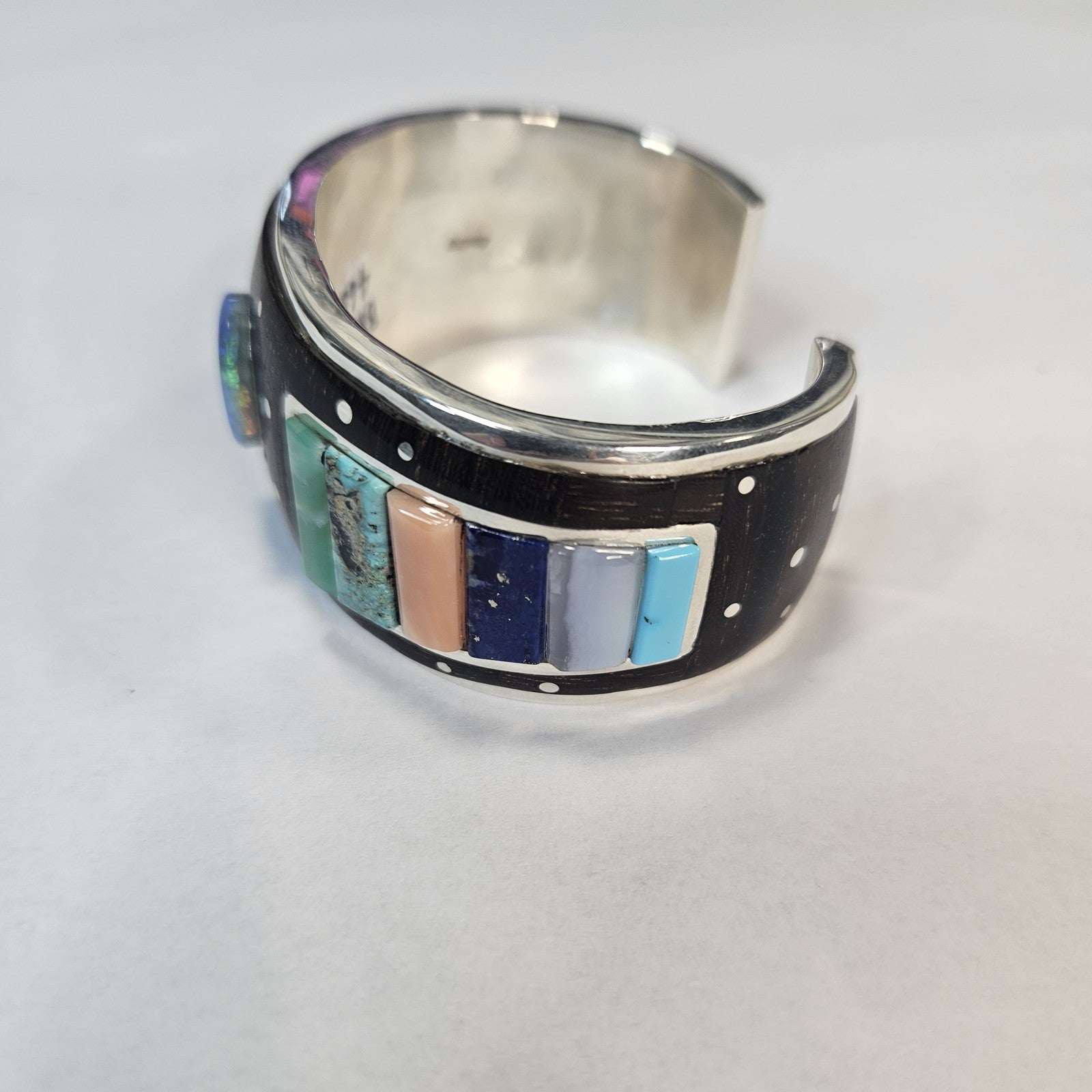 Multistone inlay cuff with central lapis cabochon and turquoise, coral, mother of pearl, and silver-dot constellation detail — Navajo handcrafted by Teddy